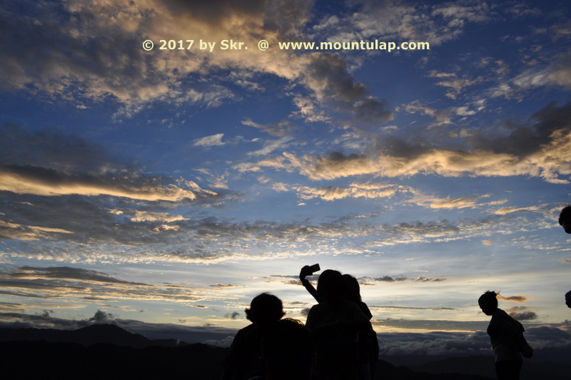 Mt. Ulap, In a mountain landscape at dawn on the 2nd. Tourist Spot is a group of night hikers sitting on top of the Rock ledge Corral-Rock and awaiting the sunrise. 
